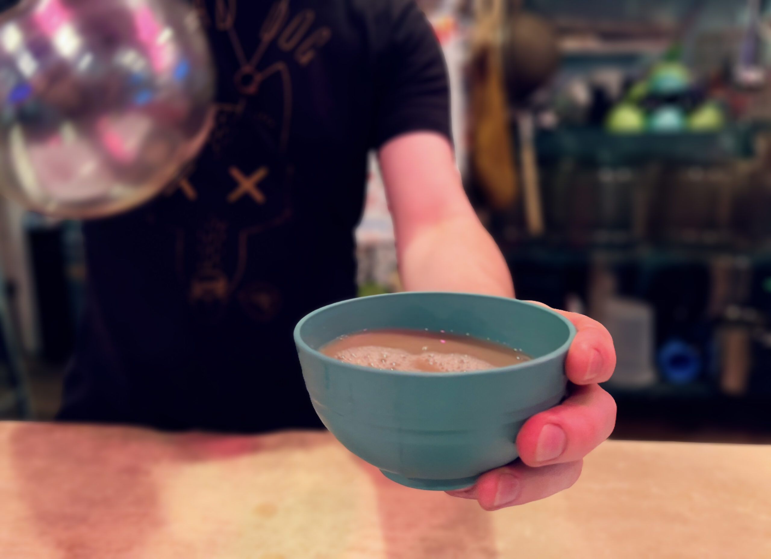 Kavatender pouring a shell of Kava at Denver's Favorite Kava Bar
