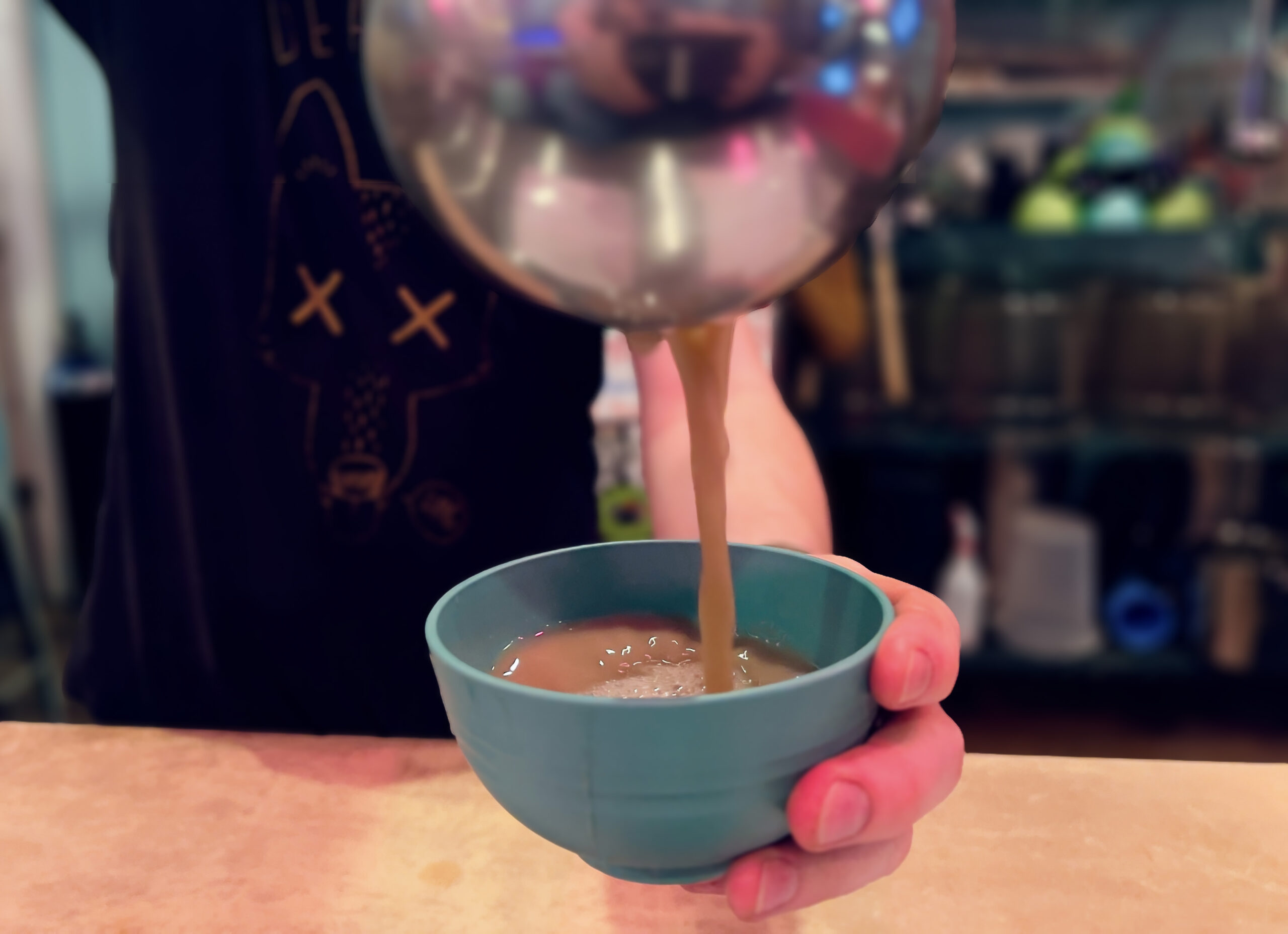 Kavatender pouring a shell of Kava at Denver's Favorite Kava Bar