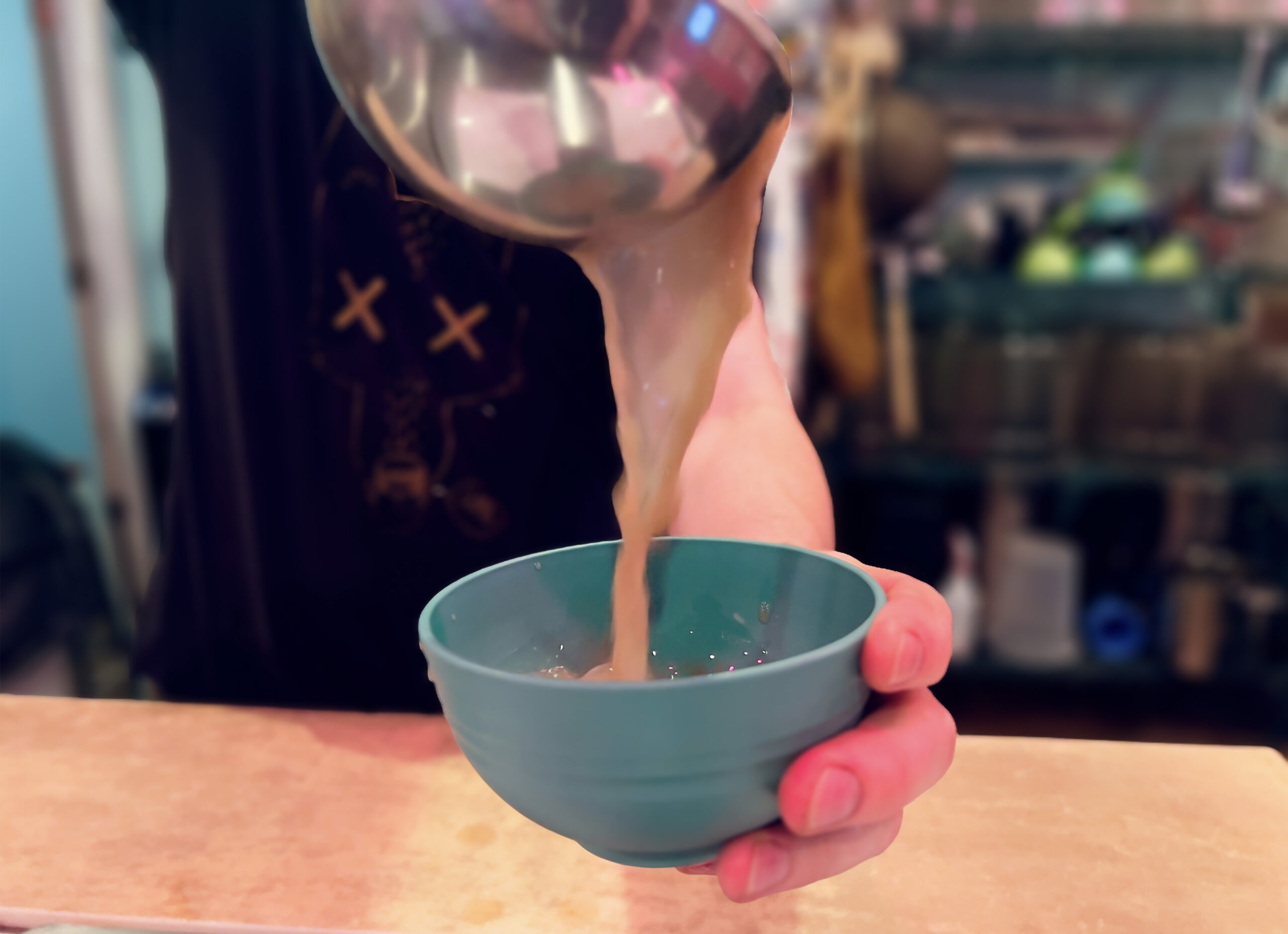 Kavatender pouring a shell of Kava at Denver's Favorite Kava Bar